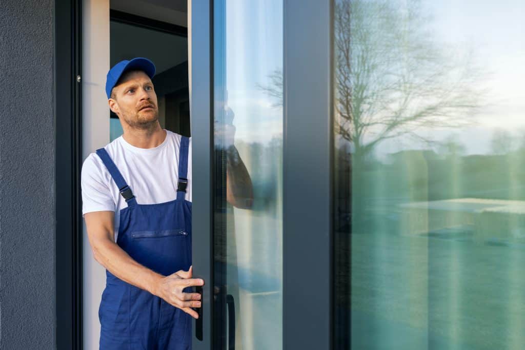 Permasol's worker installing aluminum frame sliding terrace doors 