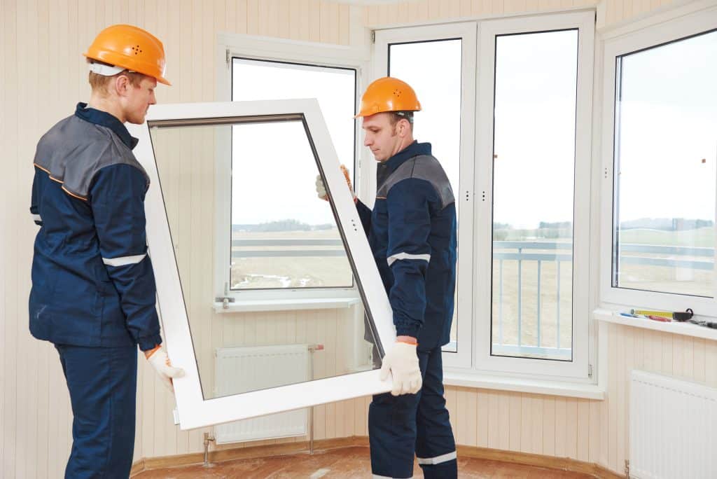 two windows installation workers replacing old windows with double-glass pane